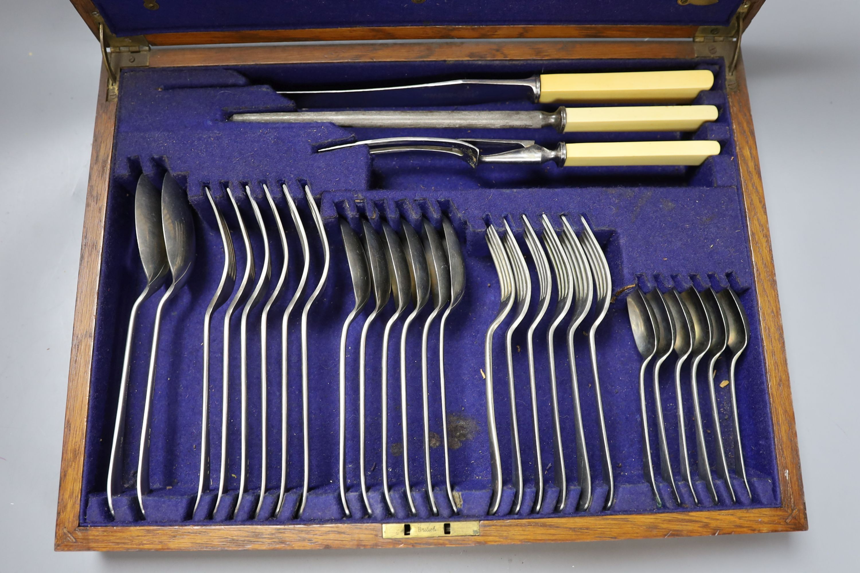 A three decanter tantalus - with labels, together with an oak canteen of table plated cutlery